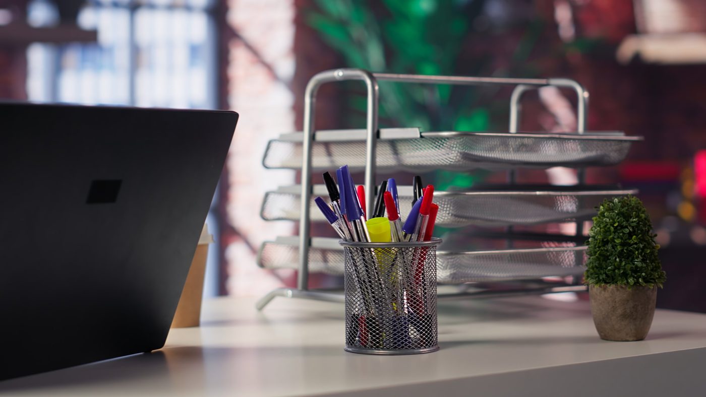 Ordinateur portable et fournitures sur un bureau à domicile.