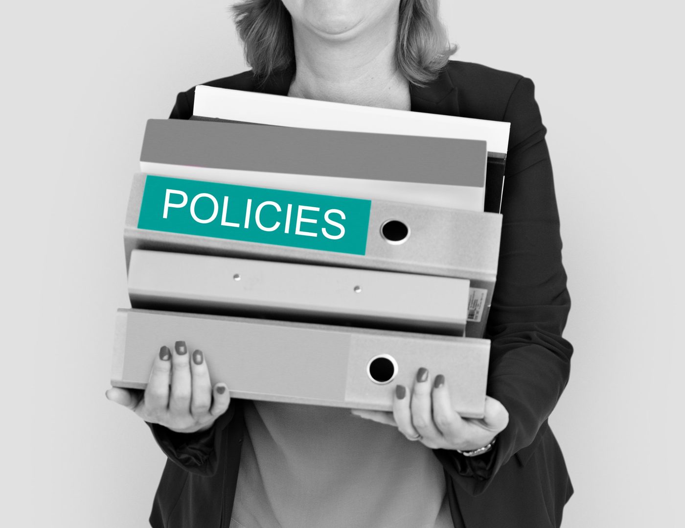 Personne portant des classeurs de politiques internes.