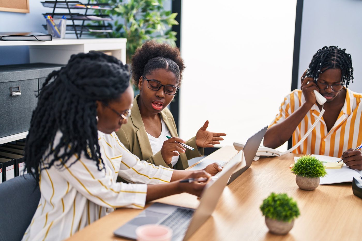 Collaborateurs au bureau, l’un au téléphone.