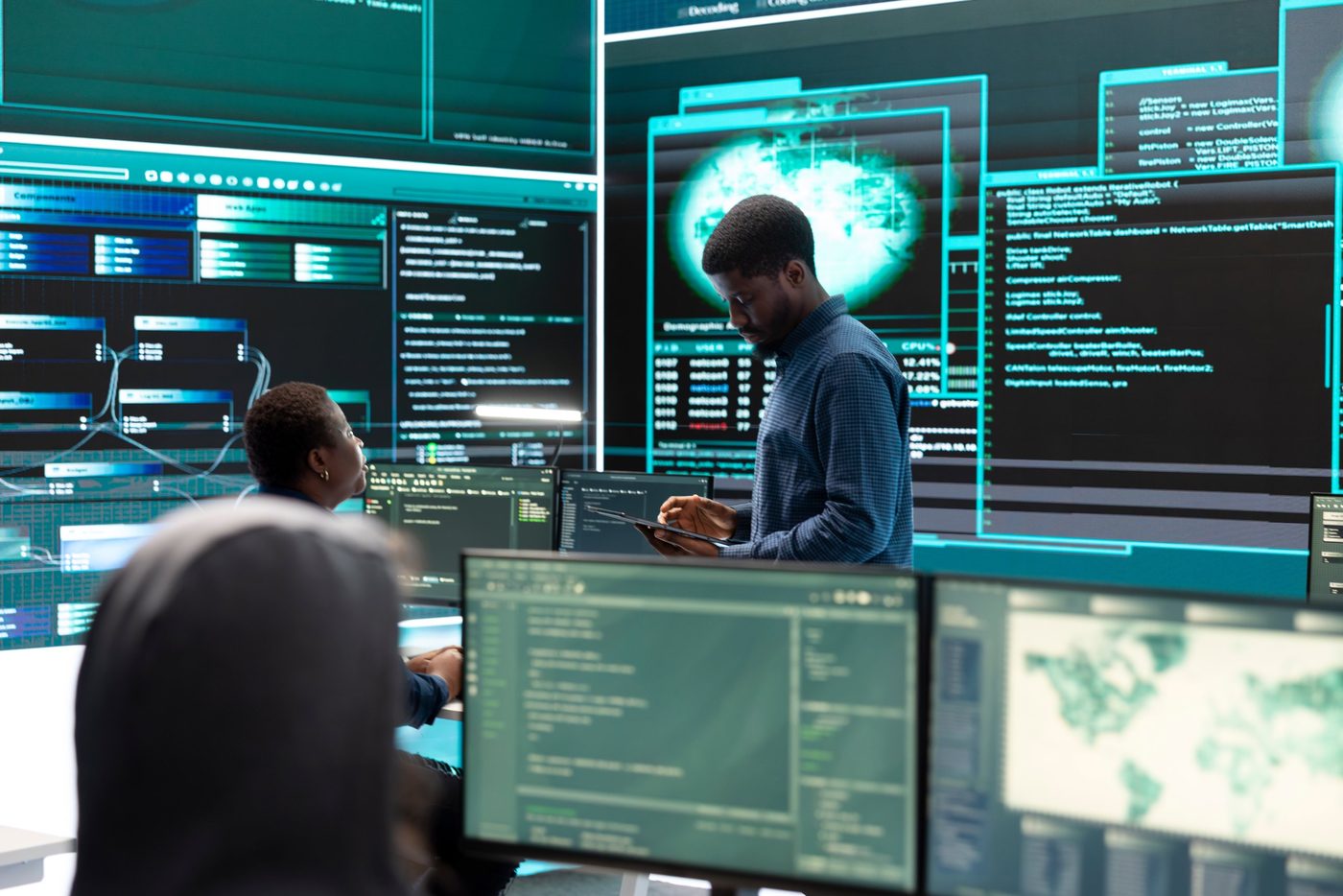 Analystes en cybersécurité surveillant des écrans de supervision.